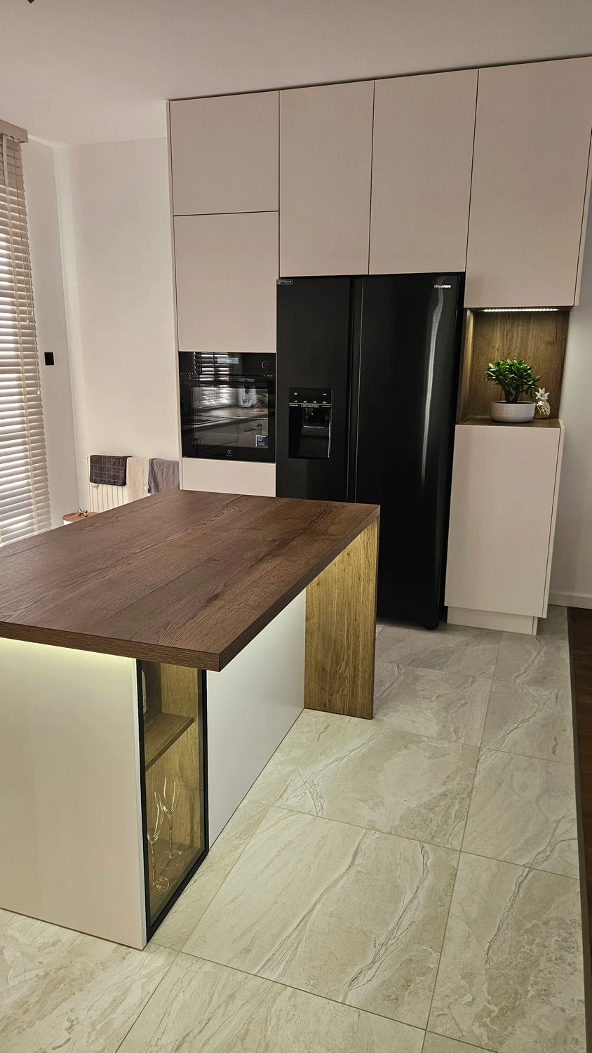 Biała kuchnia na wymiar z drewnianą wyspą i czarną lodówką side by side, Meble Mibu Gdańsk